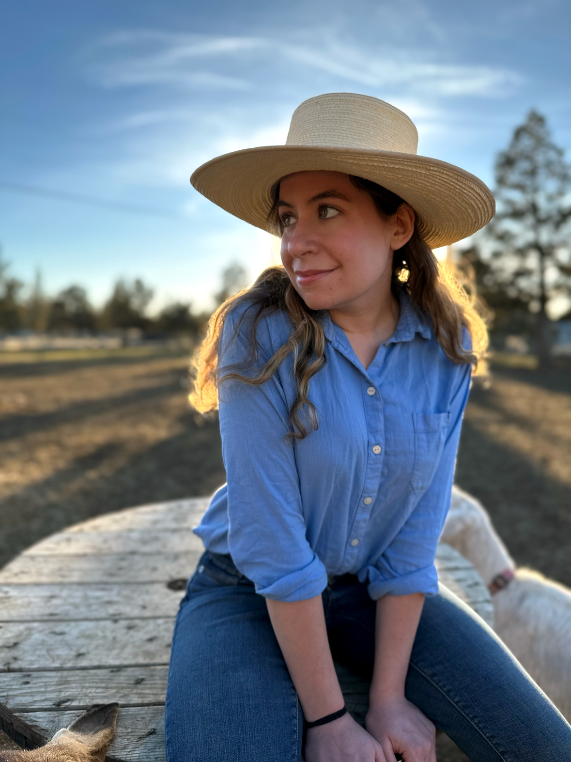 Rebecca Eke leadning agianst her barn with two goats at her sides